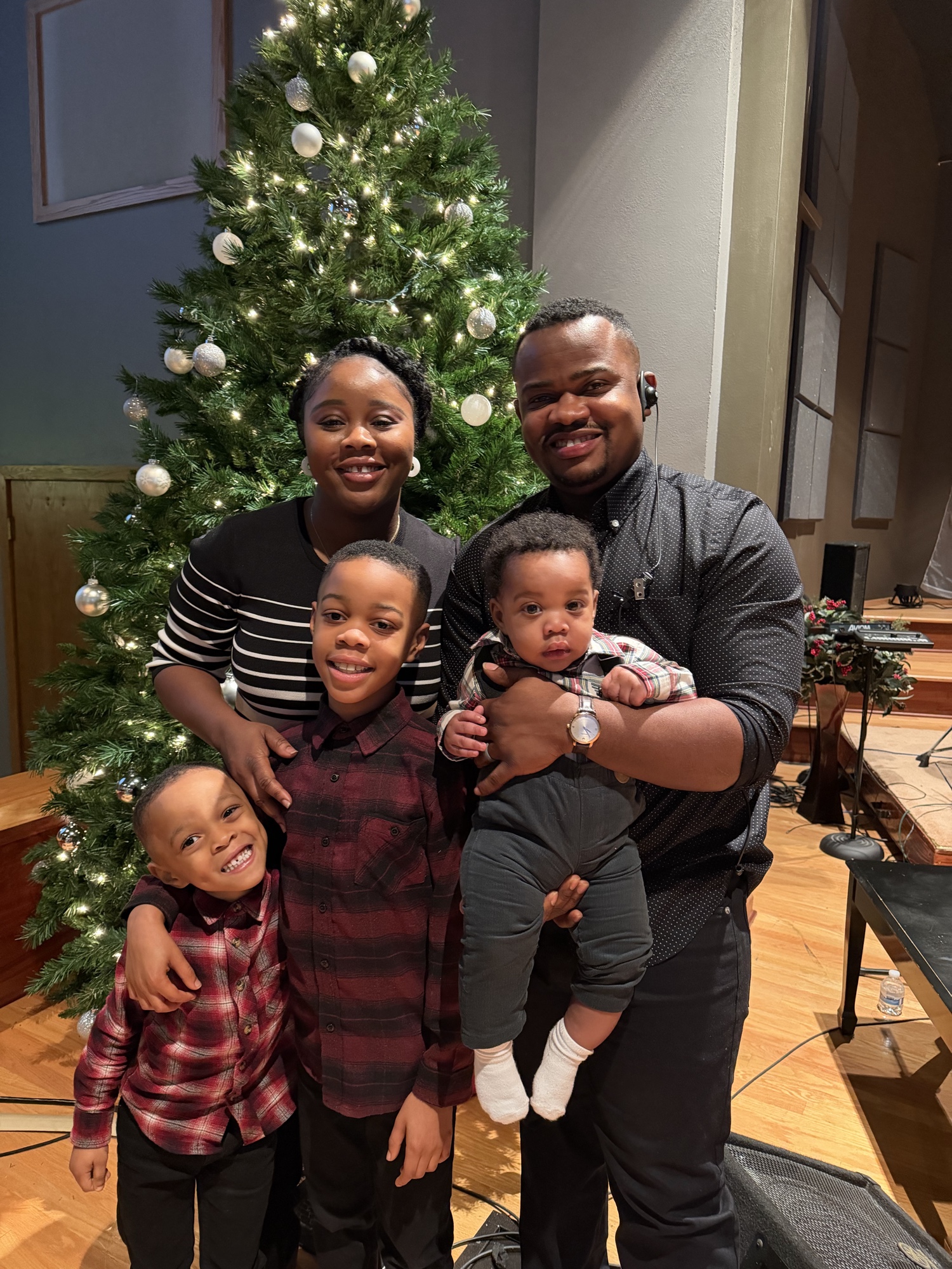 Randall R. Kollie with his wife and three sons in front of a Christmas tree.